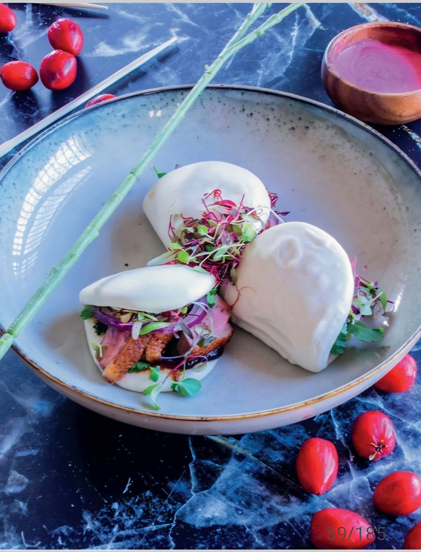 Steamed bao with Natal plum, from The Road to Kali — the fruit scattered around the plate is the amatungulu, also known as the Natal plum, big num-num or grootnoem-noem.